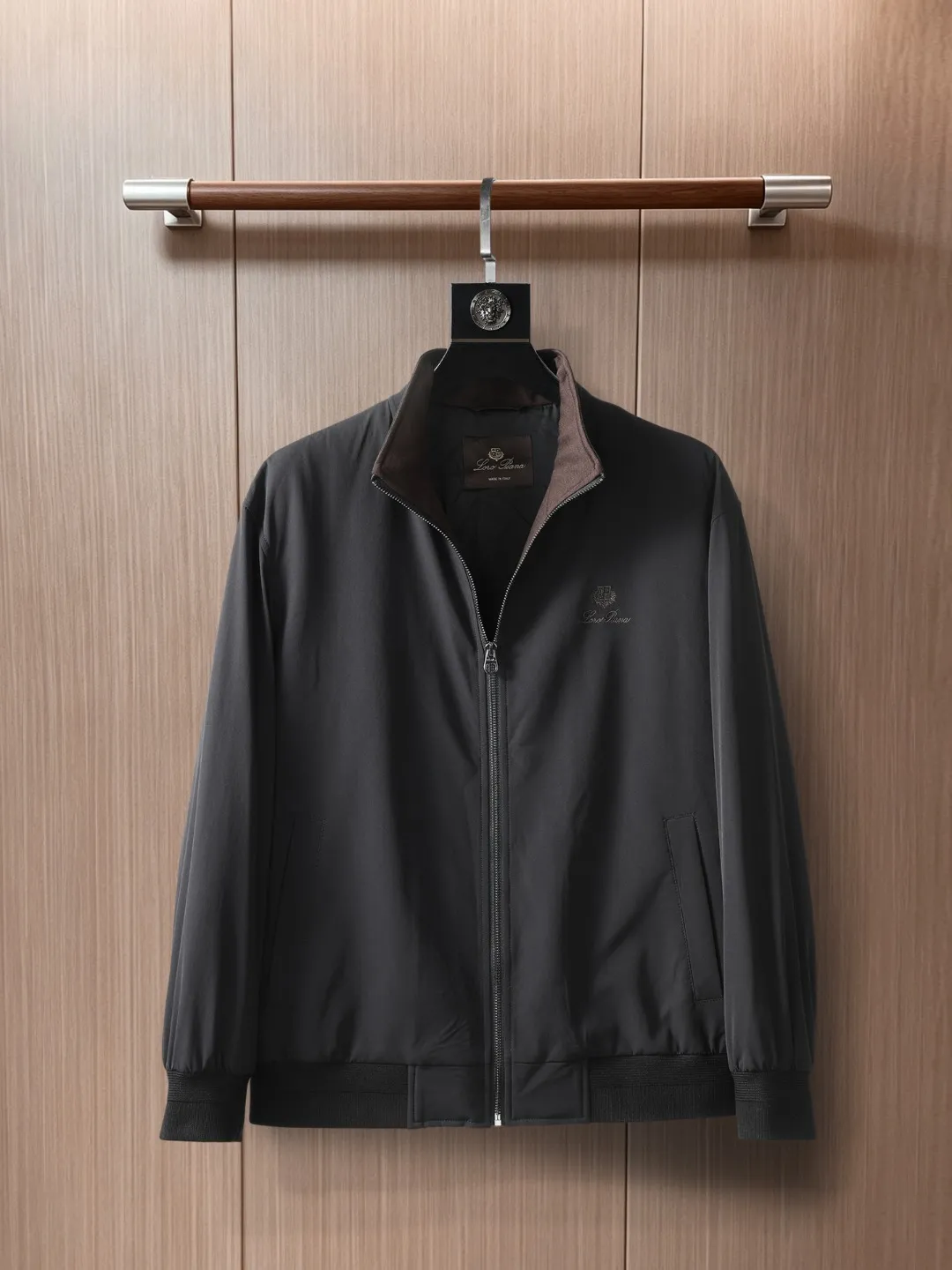 Loro Piana LP Men's Pilot Lapel Thin Cotton Jacket LP Pilot Style Cotton Jacket with Stand-up or Lapel Collar: A great choice for autumn and winter when you need both warmth and elegance. The weather has turned cooler recently. Are you looking for a jacket that is both warm and not bulky? LP's pilot cotton coat may be the answer. It uses 86.7% nylon + 13.3% cotton spandex four-way stretch fabric, and is filled with 60 g/m² of high-quality thermal insulation cotton to perfectly integrate the two seemingly contradictory needs of warmth and slimming. The first thing I felt when I put it on was "the elasticity is so good." The high-elastic fabric allows unrestricted movement, making it easy to lift your hands and turn around. The thermal insulation cotton inside is filled just right. It is not as fluffy as a down jacket, but it can effectively lock in body temperature. It is an ideal choice for weather conditions around 10℃. The thickness is controlled very smartly, so it can withstand the autumn wind when worn alone. Even if it gets colder, there is no pressure to wear it with a sweater underneath. The most surprising thing about this jacket is its ability to "transform". The 12-needle threaded knitted collar can be switched between stand-up collar and lapel modes at will. When the weather is cold, stand up the collar to keep warm, and when the temperature rises, turn down the collar for casual wear. The No. 5 resin double zipper design makes it particularly convenient to put on and take off. The zipper puller and zipper piece have been processed in the same color. From a distance, the existence of the zipper is almost invisible. This kind of control over details is really rare. The vertical zipper pockets on the chest adopt double pocket lip technology, which not only ensures practicality, but also allows the pockets to perfectly integrate into the overall lines of the clothes. The most amazing thing is the grid processing of the pocket flap and the body. This process requires more fabrics and man-hours, but the final effect is really worth it. It looks seamless from a distance, but only when you look up close can you see the carefully designed details. The cuffs and hem are made of the same 12-needle mercerized cotton thread as the collar. It has moderate elasticity without being tight, and the windproof performance is not compromised at all. The slightly wide silhouette is friendly to all body types, and the one-piece back design allows for more freedom of movement. The solid color smooth lining inside is skin-friendly and breathable, making it particularly smooth to put on and take off. The color Navy Blue is chosen just right, not too boring but still Versatile enough. Paired with casual pants, it is the perfect choice for going out on the weekends. Paired with slim-fitting trousers, it can easily cope with business and leisure occasions. Best of all, this jacket requires almost no special care and stays crisp and stylish once you hang it. This bomber jacket understands the pace of modern life best. It knows we need pieces that can handle formal occasions yet remain comfortable in everyday life. Those well-designed threaded necklines, color-matching zippers, and hidden pockets all silently enhance the wearing experience. It is not the kind of clothing that relies on exaggerated design to attract attention, but impresses you with real comfort and practicality. Color: Blue Black Size 48-56